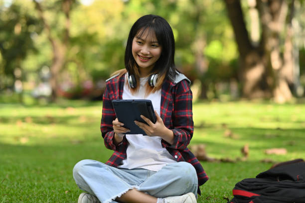 Estudiante asiática con tableta en un parque
